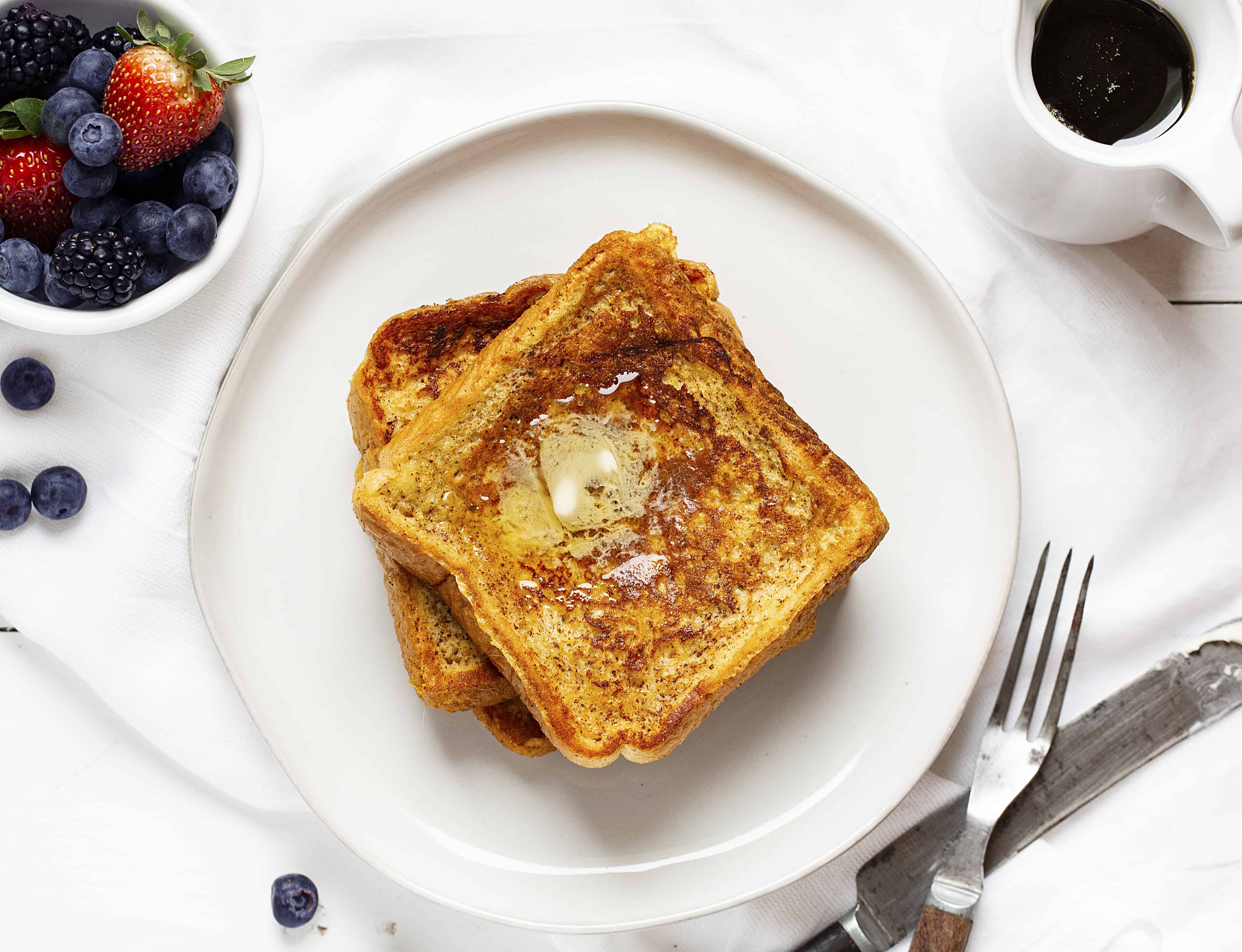This is the recipe that won't fail you! Perfect flavor and consistency, every time! #frenchtoast #easyfrenchtoast #howtomakefrenchtoast #frenchtoastrecipe #iambaker French Toast from Overhead with Fresh Fruit and Syrup.