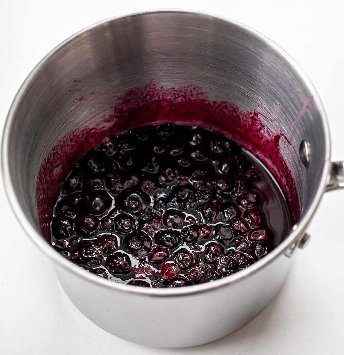 Blueberry Muffins are sweet and fluffy muffins made with fresh blueberries, homemade blueberry syrup, and a crumble topping. Double the blueberry! They are a delicious breakfast, snack, or treat to enjoy with a cup of coffee or tea and a great way to use up ripe blueberries! Pan of Blueberry Puree.
