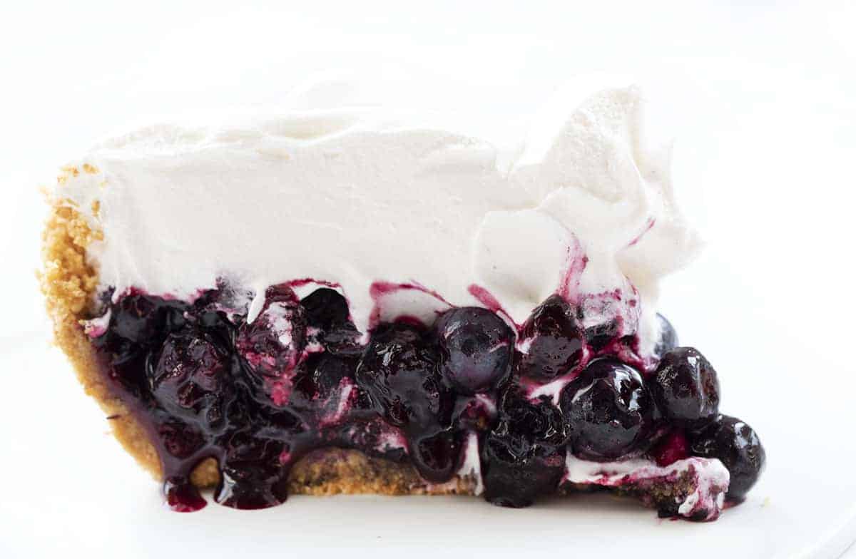 Blueberry Pie {No Bake} is an easy-to-make, refreshing pie made with fresh blueberries over a graham cracker crust topped with whipped topping. BLueberry PIe, Fresh Blueberry Pie, Blueberry Pie with Frozen Blueberries, Pie, Pie Recipes, No Bake Blueberry Pie, Easy Blueberry Pie, Summer PIe, Dessert, BBQ Dessert, no bake dessert, i am baker, iambaker Slice of No Bake Blueberry Pie