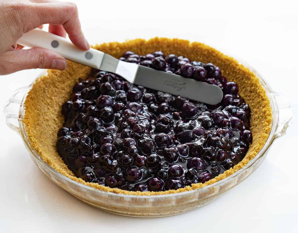 Blueberry Pie {No Bake} is an easy-to-make, refreshing pie made with fresh blueberries over a graham cracker crust topped with whipped topping. BLueberry PIe, Fresh Blueberry Pie, Blueberry Pie with Frozen Blueberries, Pie, Pie Recipes, No Bake Blueberry Pie, Easy Blueberry Pie, Summer PIe, Dessert, BBQ Dessert, no bake dessert, i am baker, iambaker Adding Blueberries to No Bake Blueberry Pie