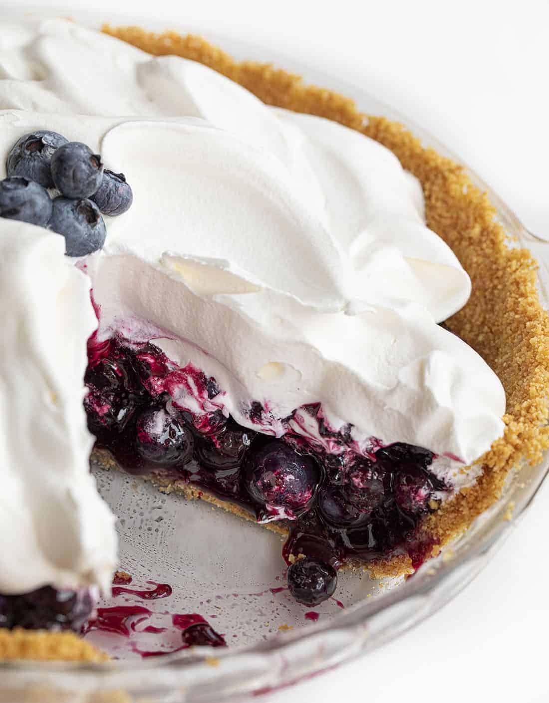Blueberry Pie {No Bake} is an easy-to-make, refreshing pie made with fresh blueberries over a graham cracker crust topped with whipped topping. BLueberry PIe, Fresh Blueberry Pie, Blueberry Pie with Frozen Blueberries, Pie, Pie Recipes, No Bake Blueberry Pie, Easy Blueberry Pie, Summer PIe, Dessert, BBQ Dessert, no bake dessert, i am baker, iambaker Cut Into Blueberry Pie