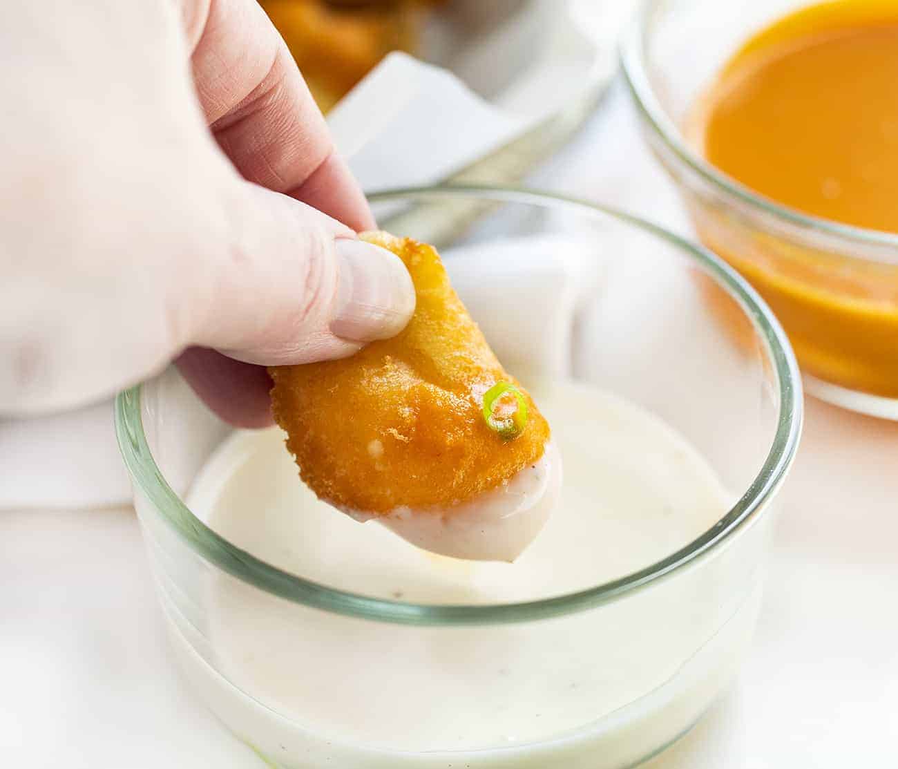 Buffalo Cheese Curds are cheese curds that are breaded in a buffalo-flavored batter using my homemade buffalo sauce and fried to a crisp golden brown. buffalo cheese curds, cheese curds, deep-fried cheese curds, fried cheese curds, white cheddar cheese curds, state fair foods, appetizers, iambaker, i am baker, homemade cheese curds Dipping Buffalo Cheese Curd into Ranch Dressing