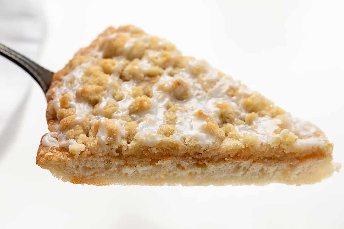 Cactus Bread is a sweet, soft, slightly spiced dessert pizza that folks who go to Pizza Ranch restaurant make a special point to get! The actual Pizza Ranch recipe is a closely guarded secret, but I think this version is just as delicious! It starts with a light and airy focaccia crust topped with cinnamon butter and a delightful crumble topping that will leave everyone craving more! One Piece of Cactus Bread Close up.