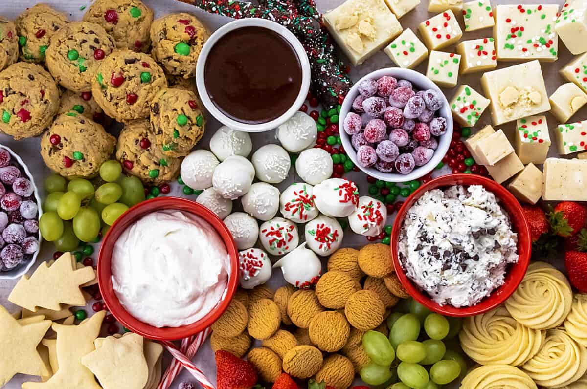 Christmas Dessert Charcuterie Board is a tray of candies, cookies, and fruit with a variety of dips for dipping. It's a beautiful and flavorful Christmas-themed display that is perfect for all of your holiday parties. It's not only a lovely display of festive treats but also delicious with lots of choices for you and your guests. It was really fun to assemble this board with colors and desserts to represent the Christmas holiday! Christmas Dessert Charcuterie Board