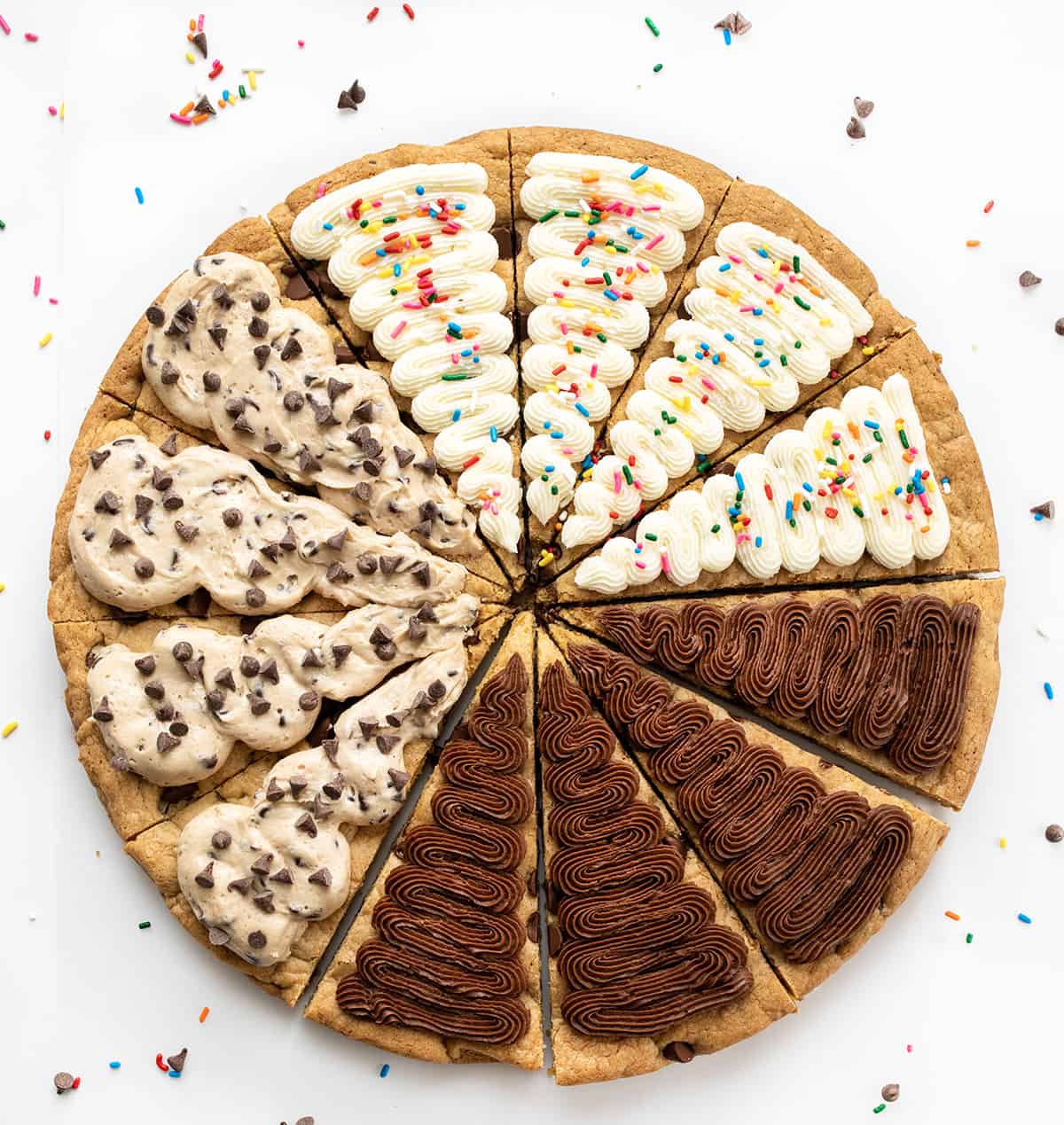 Cookie Cake For A Crowd is a colossal chocolate chip cookie frosted in three sections with cookie dough frosting, whipped chocolate buttercream, and American buttercream. The cookie itself has a soft and tender texture that is delightful on its own. Then, the frosting adds an extra layer of indulgence! It's like three treats in one! Cookie Cake for a Crowd with Chocolate Frosting, Vanilla Frosting, and Cookie Dough Frosting.