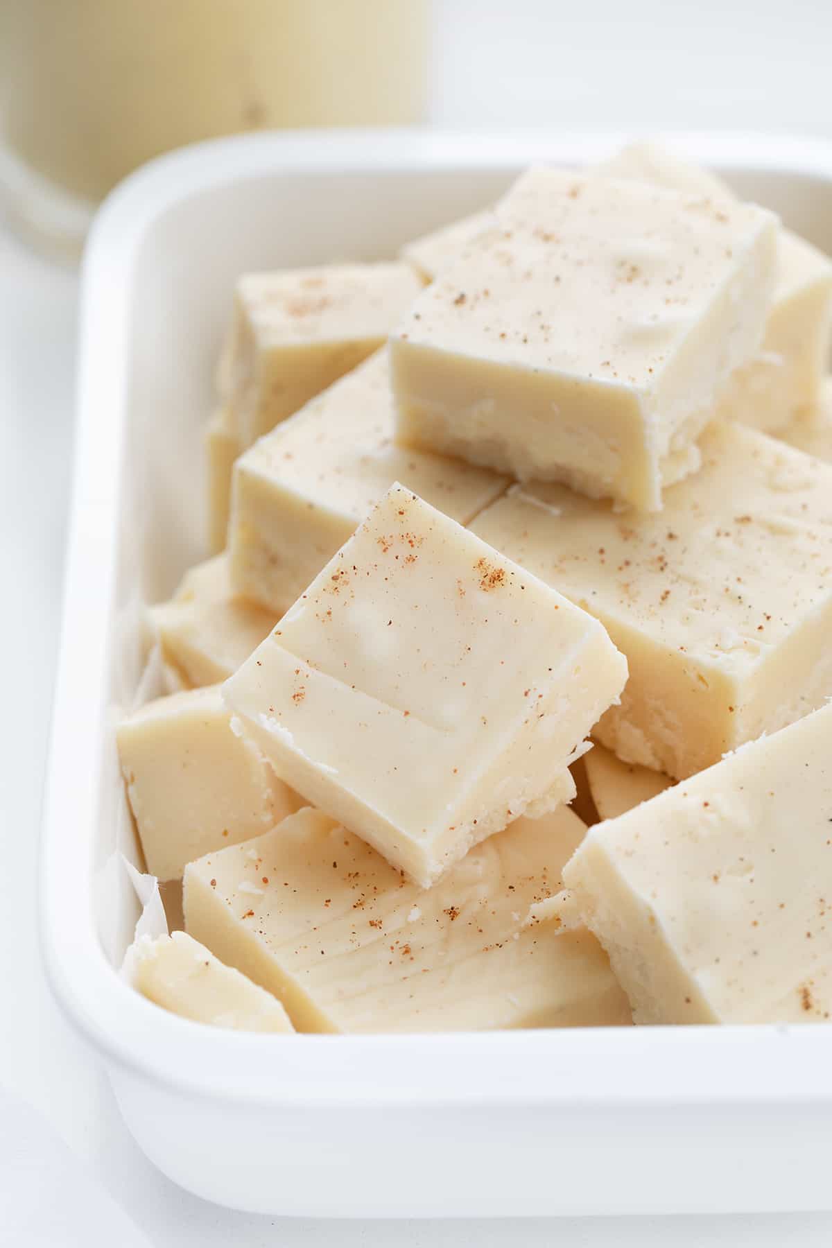 Eggnog Fudge Once you see how easy this eggnog fudge recipe is, you will want to make other varieties! And, with eggnog as one of the main ingredients, it’s a must for your New Year’s Eve celebrations. In addition, with the popularity of Christmas dessert charcuterie boards, pieces of this fudge would be a perfect addition to the board! Eggnog Fudge in a Container Stacked up.