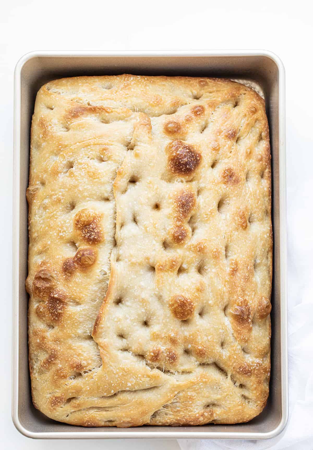 Sourdough Focaccia is fluffy and chewy on the inside with a crispy outside, made with an active sourdough starter for that sourdough flavor in every bite! It is delicious on its own, but also pairs wonderfully with various spreads and dipping options. Plus, it is made in a baking dish with just a few ingredients and no yeast. If you have a little patience, you can certainly make this bread. Sourdough Focaccia Baked in a Pan.