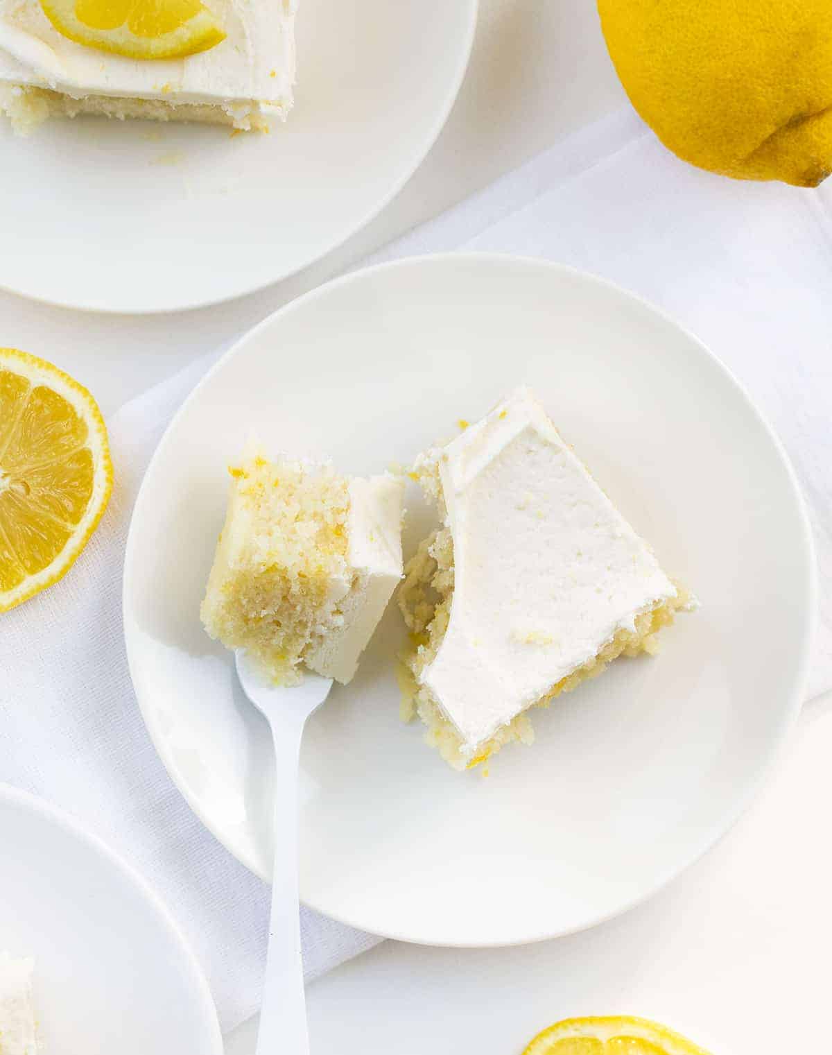Lemon Crazy Cake is a cake made without milk, eggs, or butter, but full of lemon flavor with a light and fluffy lemon buttercream on top. Lemon Depression Cake, Lemon Wacky Cake, Crazy Cake, Wacky Cake, Depression Cake, Cake with No Milk, Lemon Cake with No Eggs, Lemon Cake with No Butter, Dairy Free Lemon Cake, Desserts, Baking, Summer time desserts, lemon buttercream, recipes, i am baker, iambaker Pieces of Lemon Crazy Cake from Overhead with One Piece and Fork.