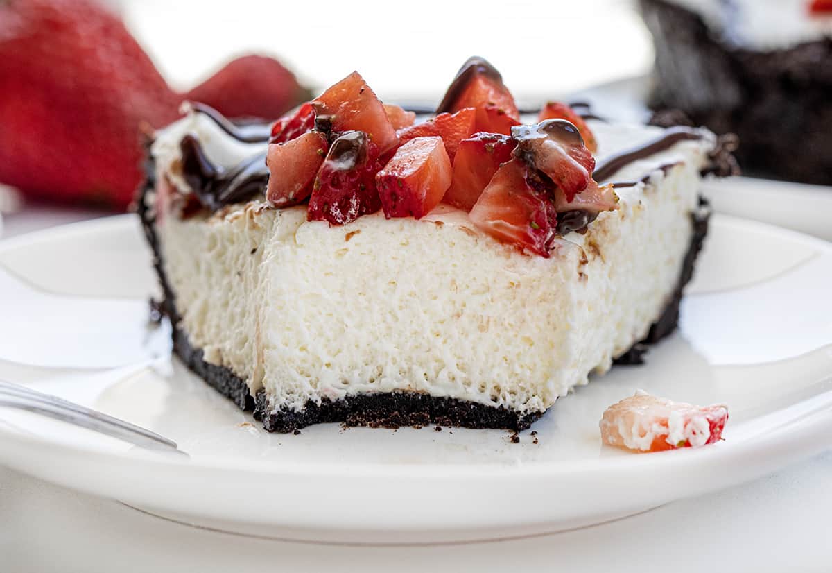 Chocolate Strawberry Marshmallow Pie is a creamy and delicious pie with an Oreo cookie crust filled with a fluffy marshmallow mixture. Then it is casually topped with chopped fresh strawberries and hot fudge! It is a no-bake dessert that would be delightful year-round, but especially in the summertime with fresh strawberries! Close up of the Texture of a Chocolate Strawberry Marshmallow Pie After a Bite has Been Removed.