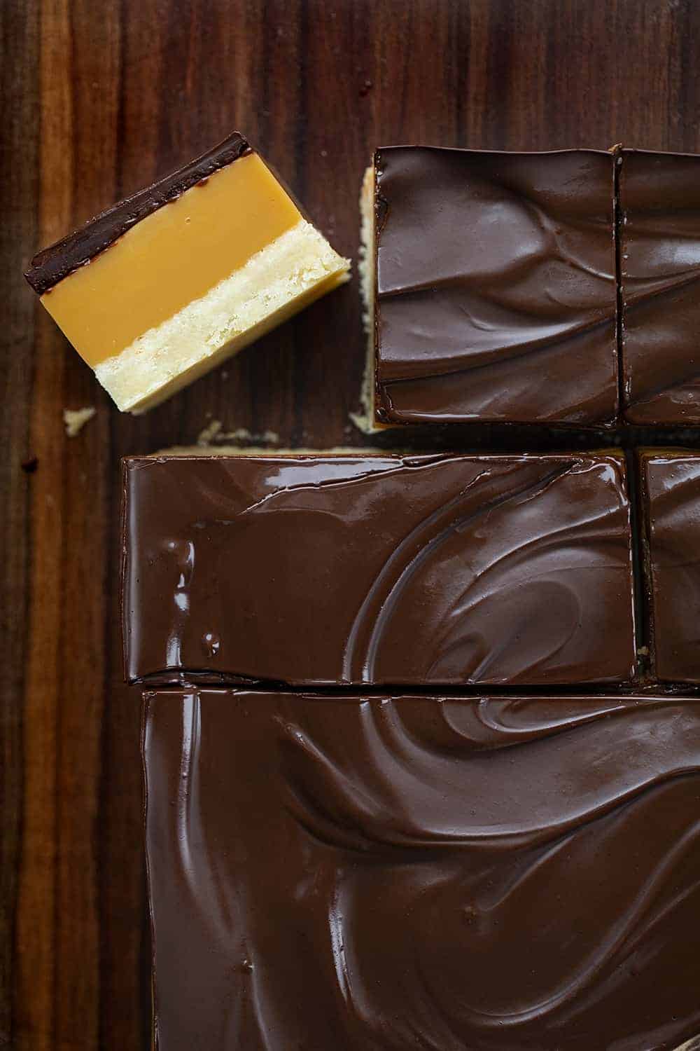Millionaire's Bars are a sweet, layered dessert made with a shortbread crust, caramel filling, and a semi-sweet chocolate topping. Millionaire Bars, How to Make Millionaire Bars, The Best Millionaire Bars, Billionaire Bars, Bars, Dessert, Recipes, Chocolate, Caramel, Soft Caramel, i am baker, iambaker Cut Millionaire Bars