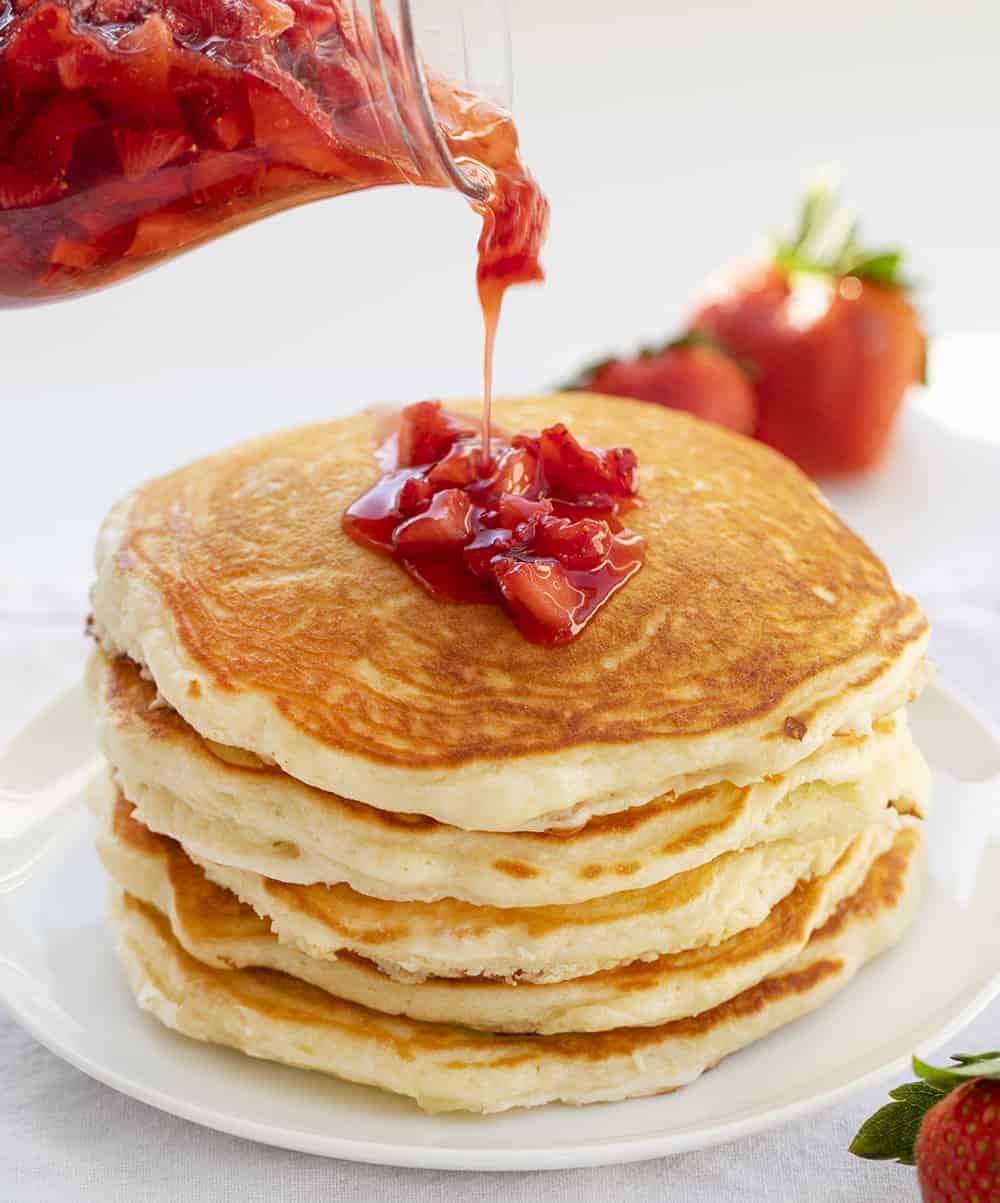 Strawberry Cheesecake Pancakes are fluffy buttermilk pancakes with a cream cheese swirl inside and topped with strawberry syrup. Pancakes, Strawberry Cheesecake Pancakes, Cheesecake Pancakes, Breakfast, Buttermilk Pancakes, Best Pancake Recipe, i am baker, iambaker, recipes Adding Strawberry Syrup to Buttermilk Pancakes