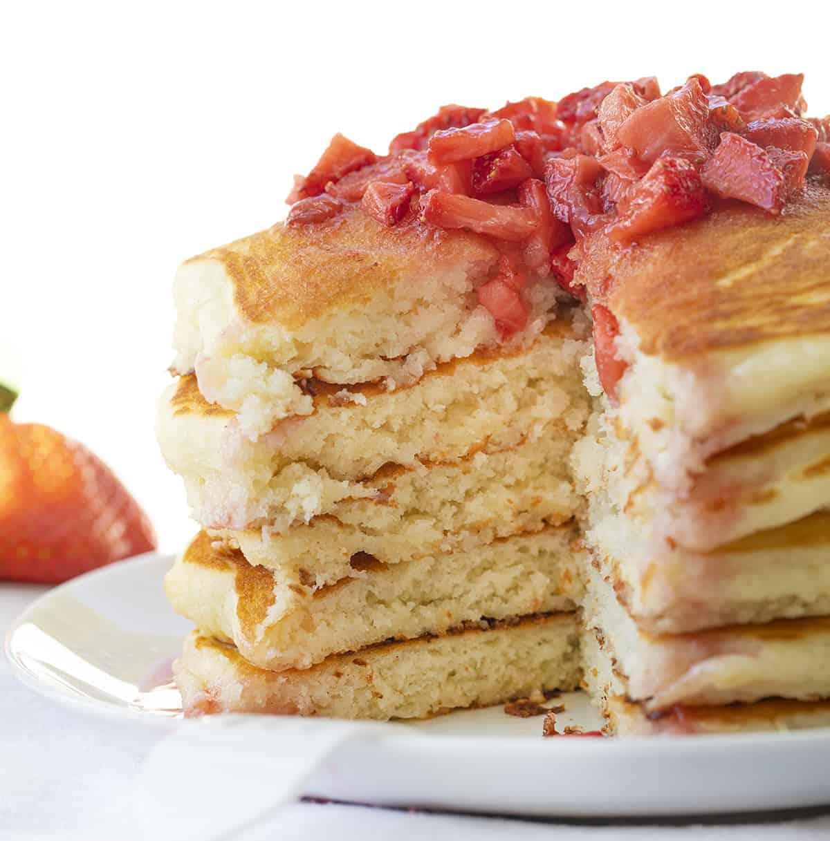 Strawberry Cheesecake Pancakes are fluffy buttermilk pancakes with a cream cheese swirl inside and topped with strawberry syrup. Pancakes, Strawberry Cheesecake Pancakes, Cheesecake Pancakes, Breakfast, Buttermilk Pancakes, Best Pancake Recipe, i am baker, iambaker, recipes Strawberry Cheesecake Pancakes Cut Into Showing Inside
