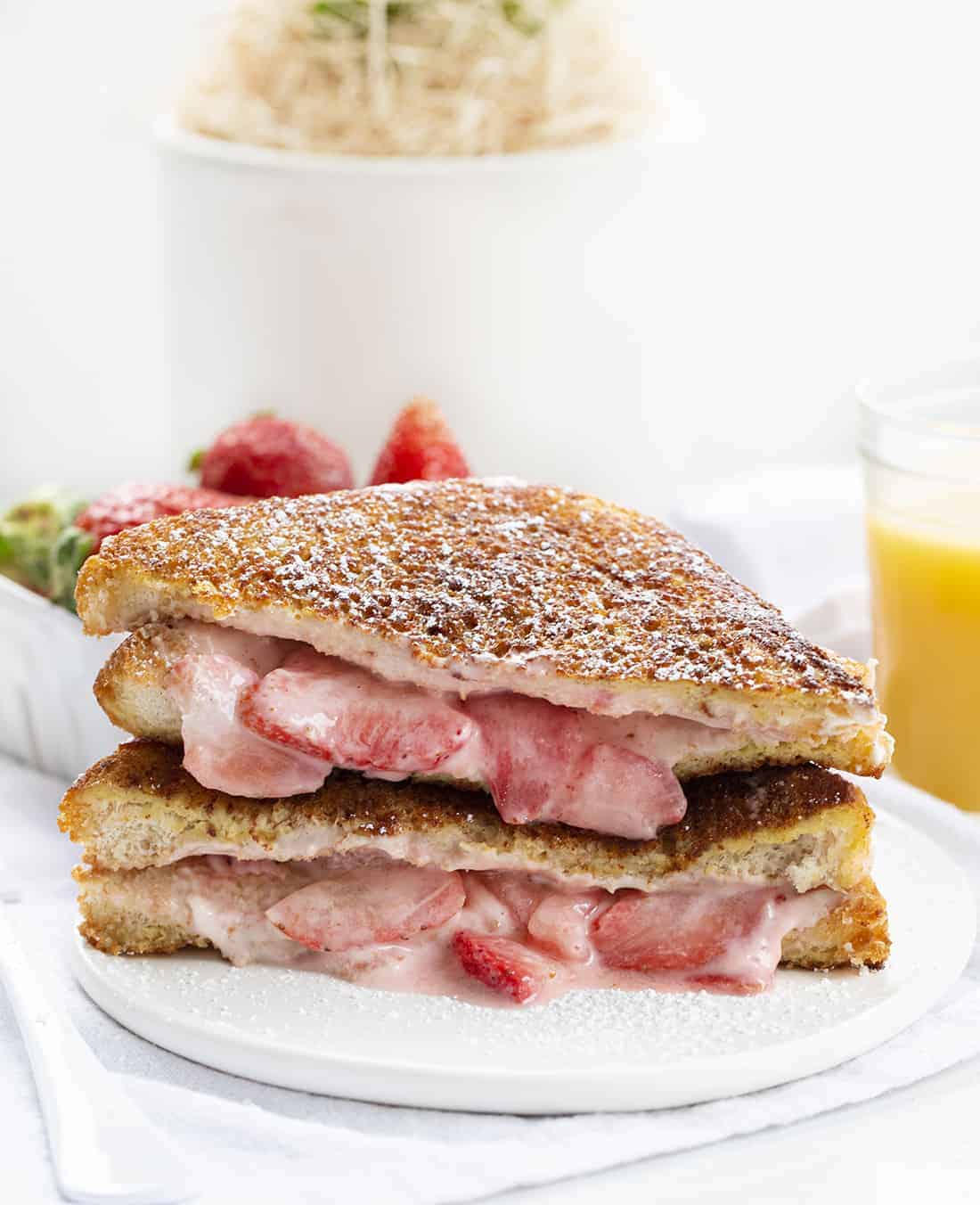 Stuffed French Toast is covered with a cinnamon and sugar coating and filled with cream cheese and juicy strawberries, topped with confectioners’ sugar and whipped cream. Stuffed French Toast, How to Make Stuffed French Toast, Stuffed French Toast Recipe, Breakfast, French Toast, Recipes, i am baker, iambaker Plate of Stuffed French Toast with Strawberries